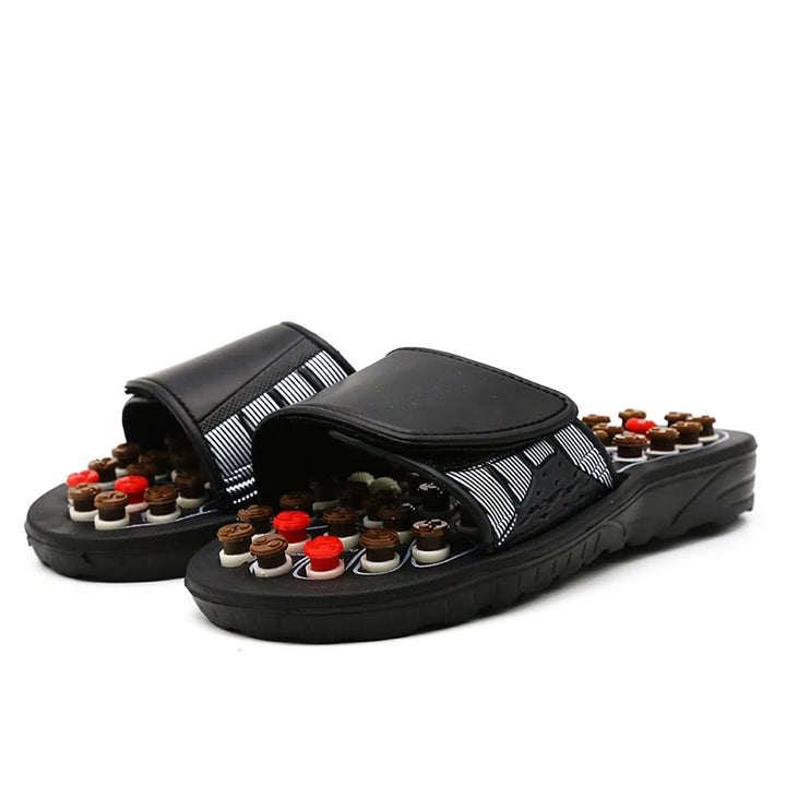 Black massage sandals with multiple small round nodes on a white background