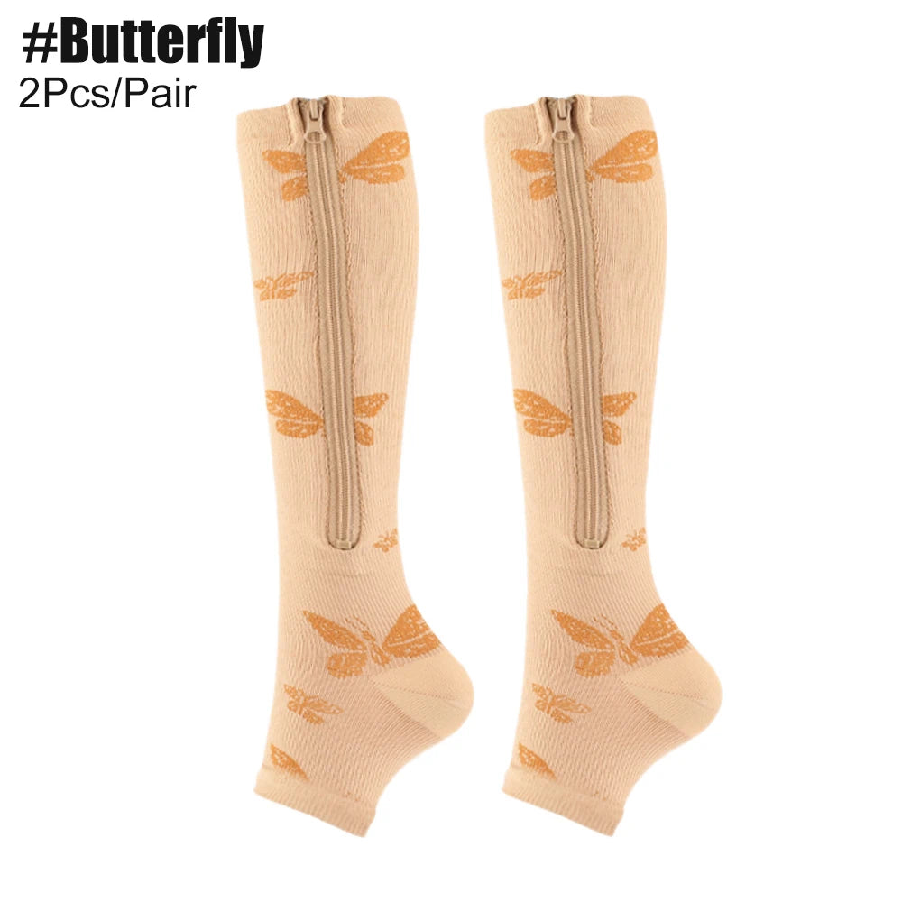 Beige knee-high socks with butterfly designs and zippers on a white background.