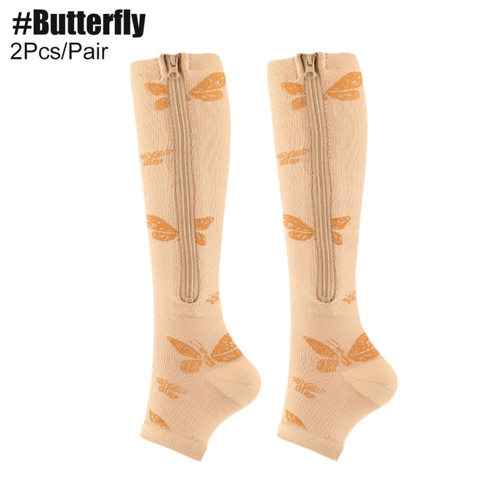 Beige knee-high socks with butterfly designs and zippers on a white background.