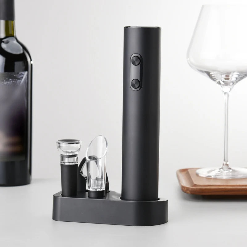 Black electric wine opener on a white surface with a wine bottle and glass in the background.