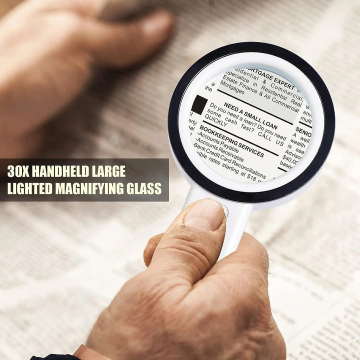 Handheld magnifying glass held by a person over printed text on paper.