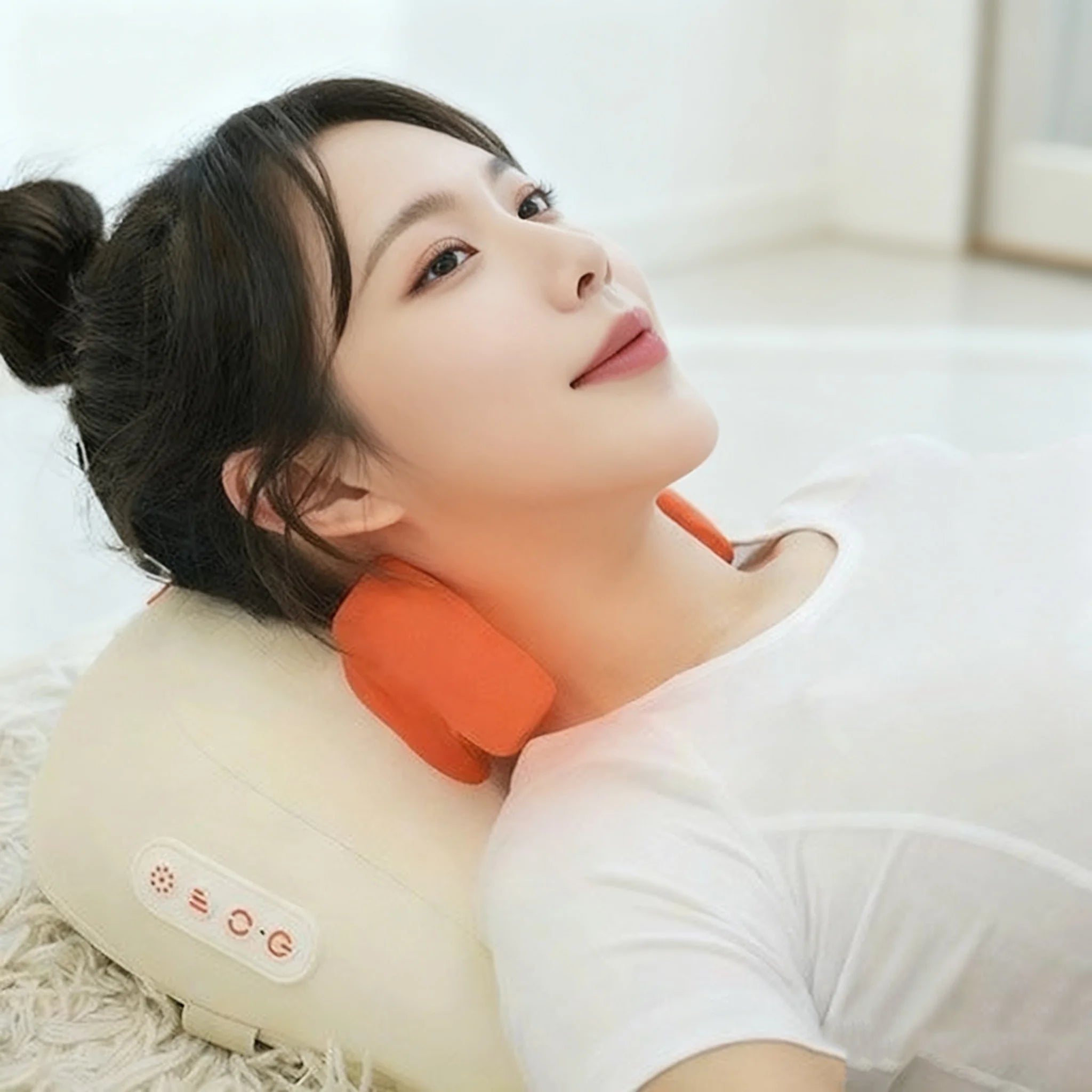 Woman using a neck massager with an orange cushion on a white background