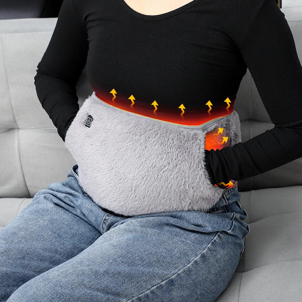 Person using a heating pad on their lap with a gray background