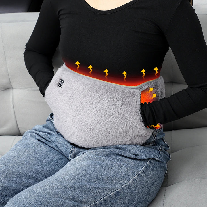 Person using a heating pad on their lap with a gray background